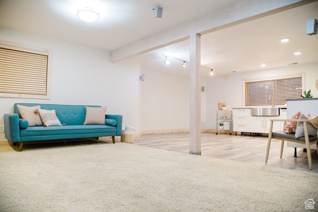 Sitting room featuring rail lighting, beam ceiling, and light hardwood / wood-style flooring