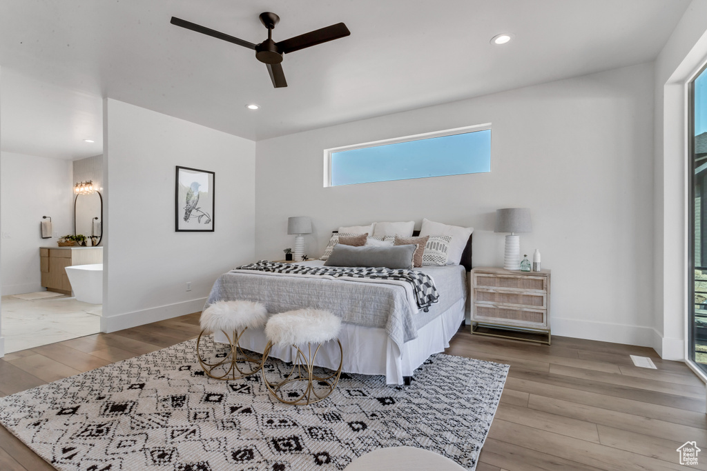 Bedroom featuring ensuite bath, ceiling fan, and hardwood / wood-style flooring