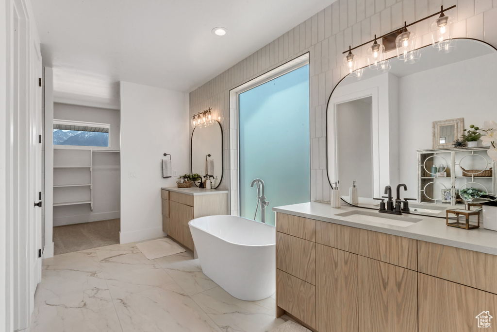Bathroom featuring tile flooring, a bath, and vanity