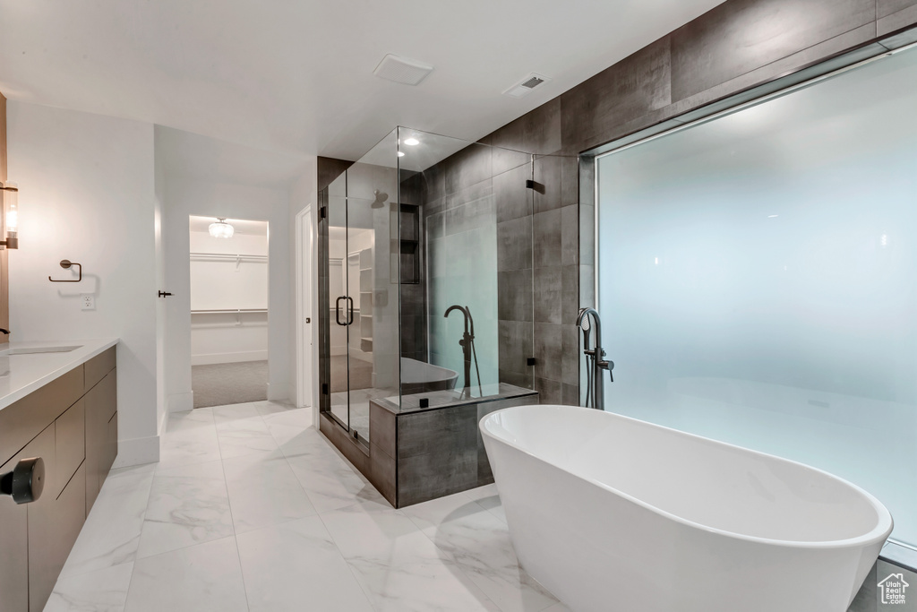 Bathroom featuring vanity, shower with separate bathtub, and tile floors