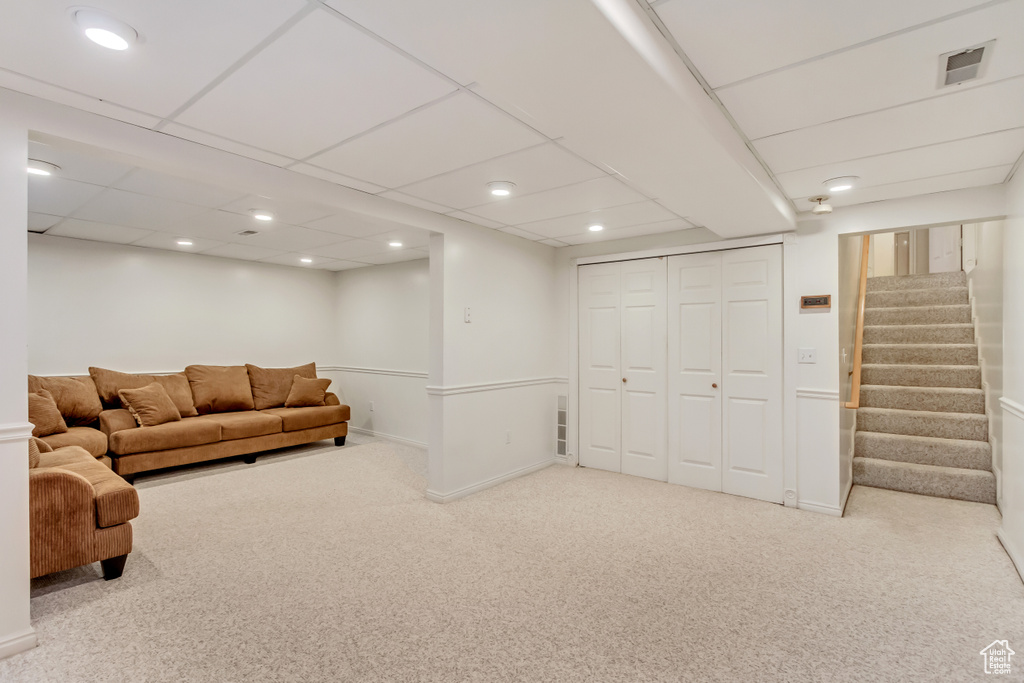 Living room featuring light colored carpet and a paneled ceiling