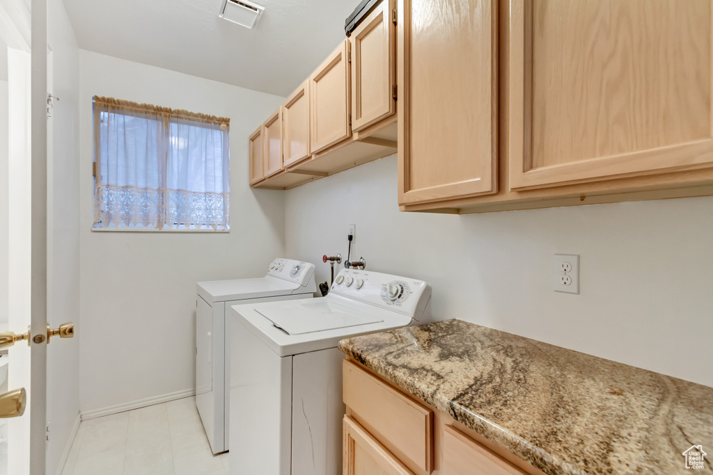 Laundry area with washing machine and clothes dryer, hookup for a washing machine, cabinets, and light tile flooring