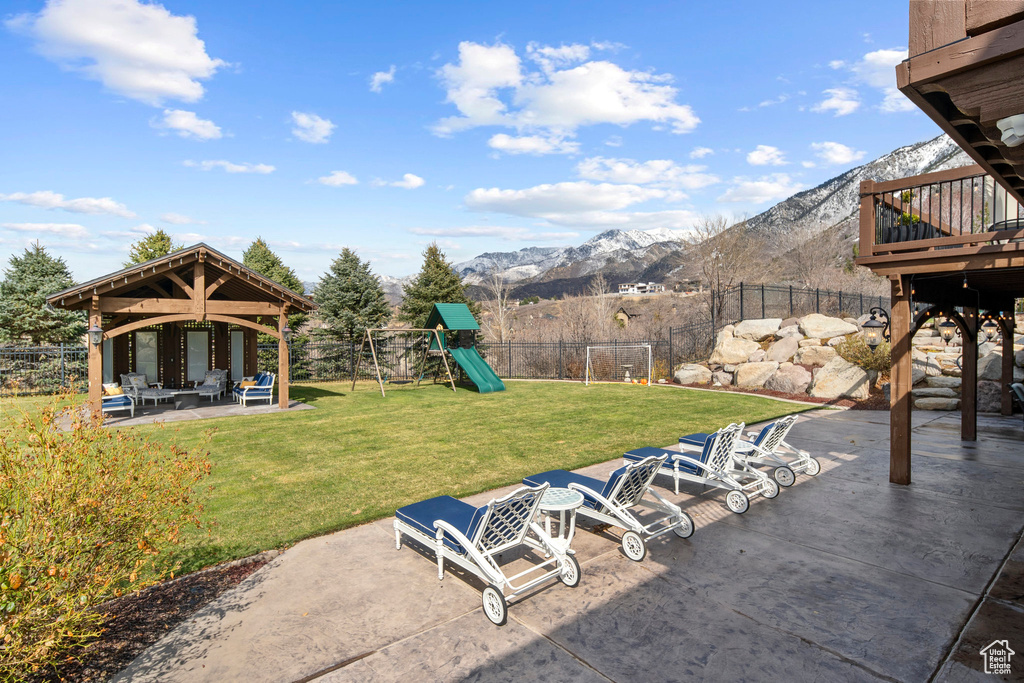 View of yard featuring a playground, a patio, a gazebo, and a mountain view