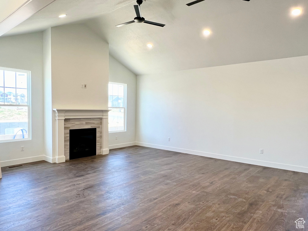 Unfurnished living room with high vaulted ceiling, dark wood-type flooring, ceiling fan, and a fireplace