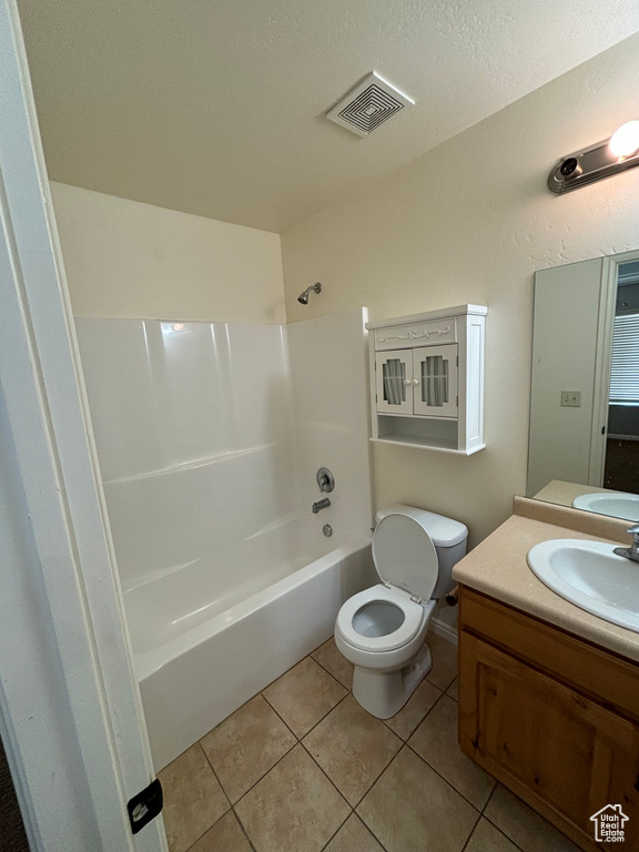 Full bathroom with tile flooring, toilet, vanity, and bathtub / shower combination