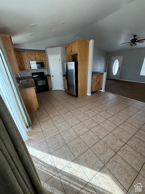 Kitchen featuring ceiling fan, appliances with stainless steel finishes, light tile floors, and sink