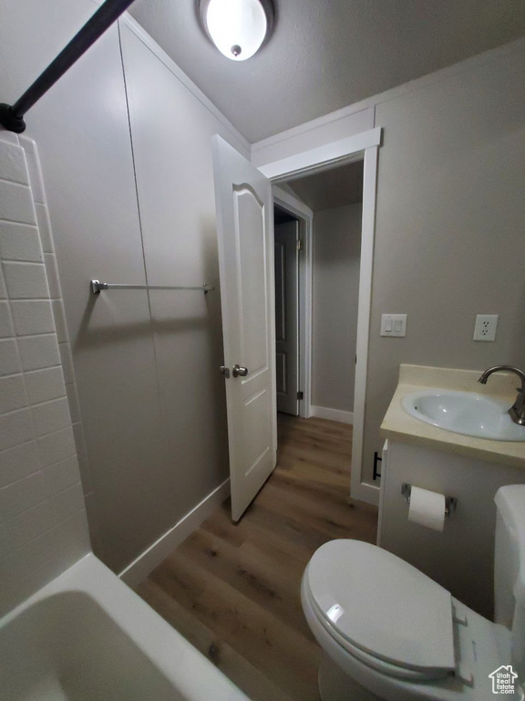 Full bathroom with toilet, bathtub / shower combination, vanity, and wood-type flooring