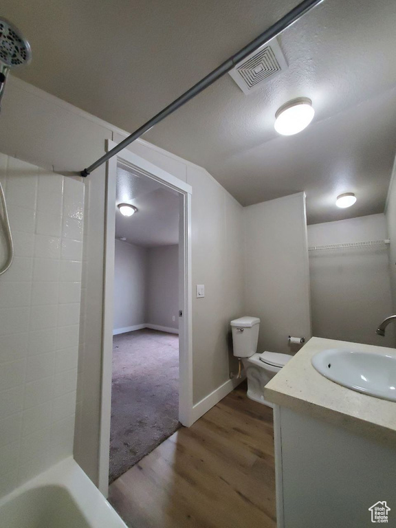Full bathroom with toilet, hardwood / wood-style floors, shower / tub combination, a textured ceiling, and vanity