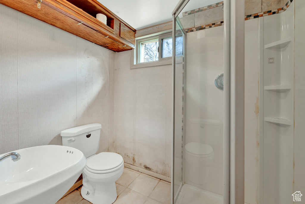 Bathroom with tile floors, toilet, walk in shower, and sink