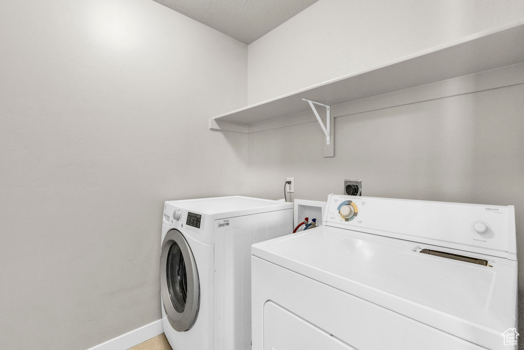 Washroom with washer hookup, electric dryer hookup, and washing machine and clothes dryer