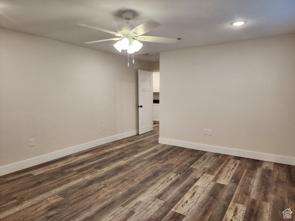 Spare room with dark hardwood / wood-style floors and ceiling fan