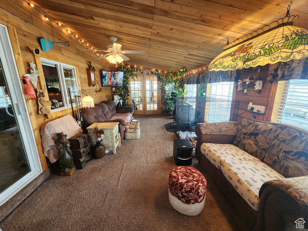 Living room featuring plenty of natural light, carpet floors, ceiling fan, and lofted ceiling