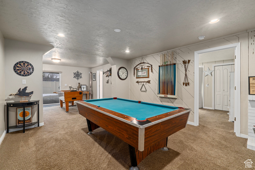 Game room featuring light carpet, pool table, and a textured ceiling