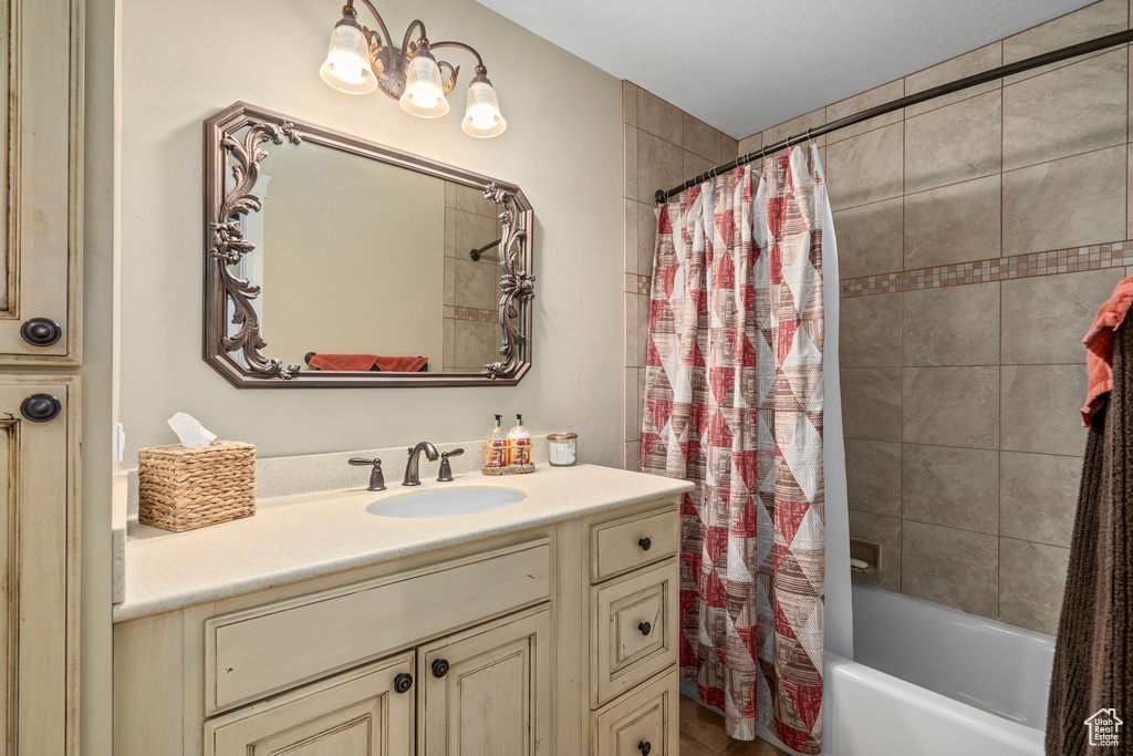 Bathroom featuring vanity and shower / bathtub combination with curtain