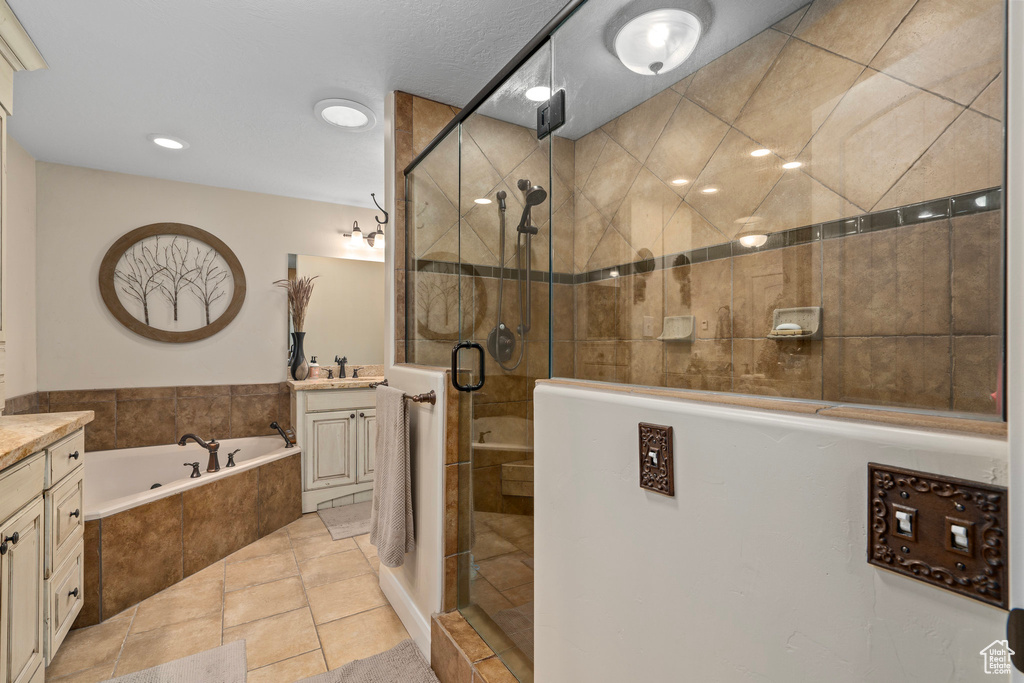 Bathroom featuring tile floors, vanity, and plus walk in shower