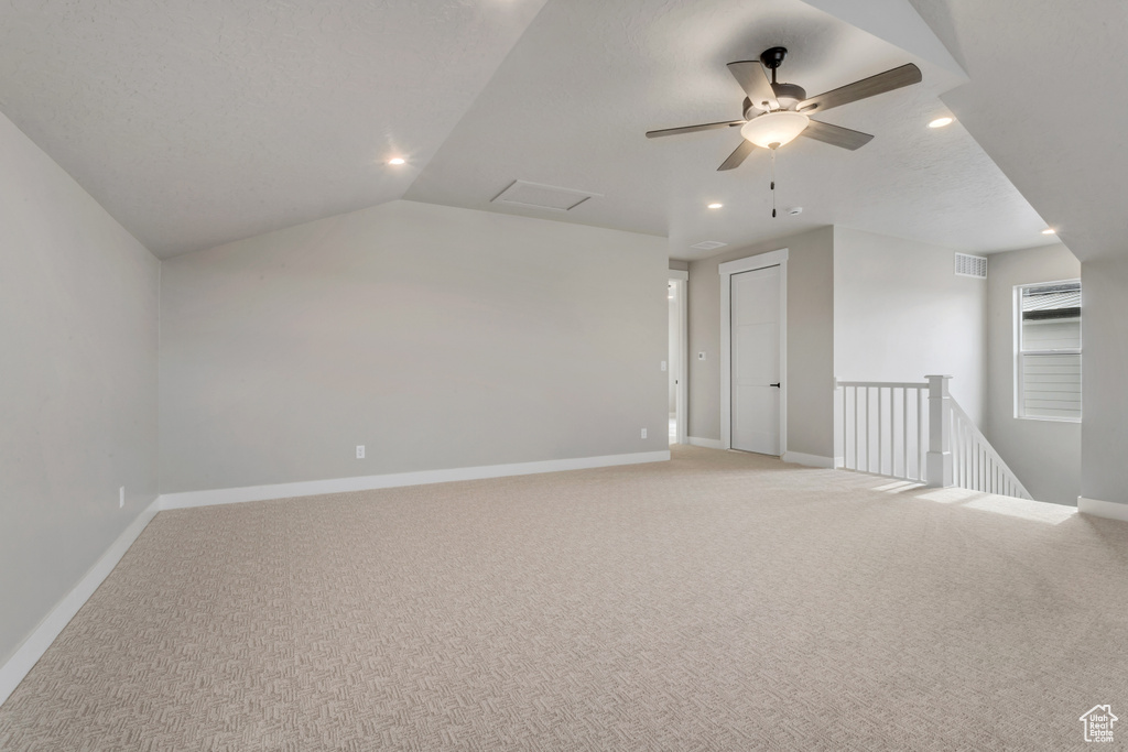 Bonus room featuring light carpet, vaulted ceiling, and ceiling fan