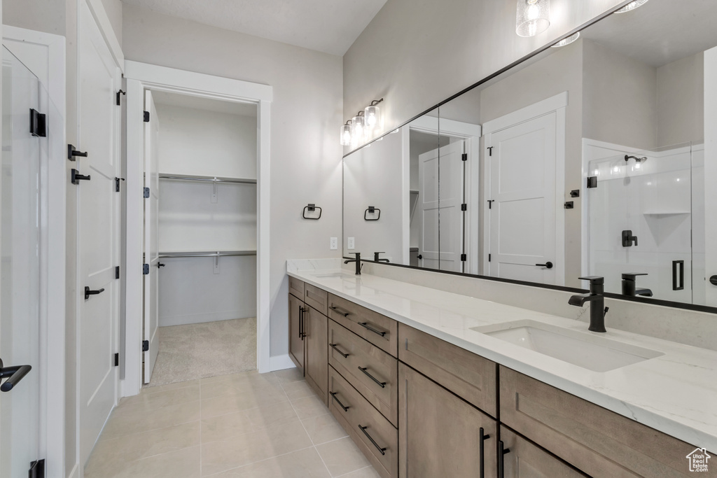Bathroom with tile flooring, large vanity, and double sink