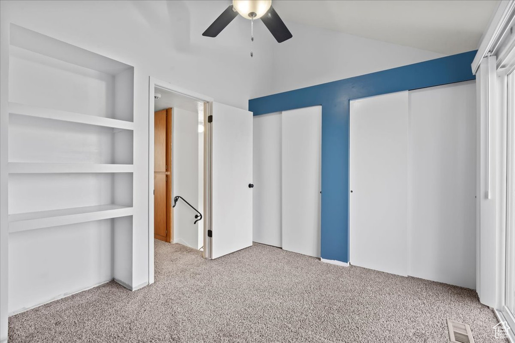 Unfurnished bedroom featuring ceiling fan and light colored carpet