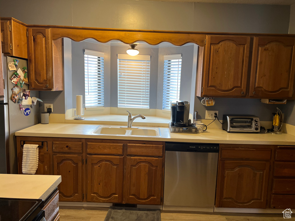 Kitchen featuring light hardwood / wood-style flooring, stainless steel appliances, sink, and a wealth of natural light