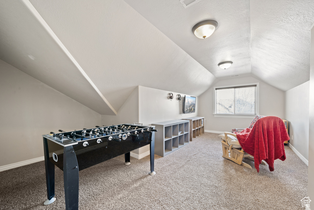 Rec room with vaulted ceiling and carpet