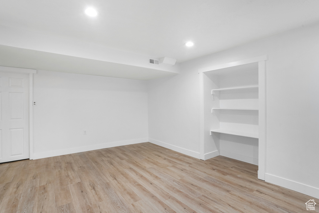 Unfurnished bedroom with light hardwood / wood-style floors, a spacious closet, and a closet