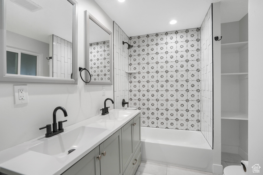 Bathroom featuring tiled shower / bath combo, tile flooring, dual sinks, and large vanity