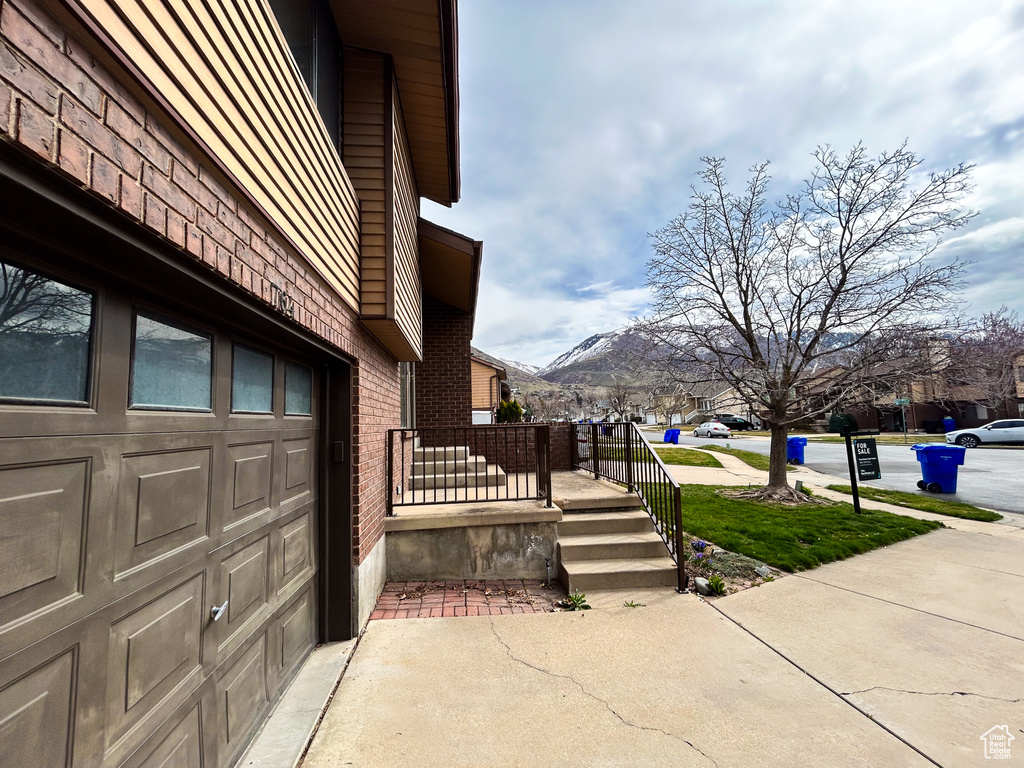 View of side of home featuring a mountain view and a garage