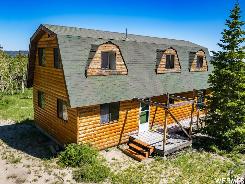 Log-style house featuring a wooden deck