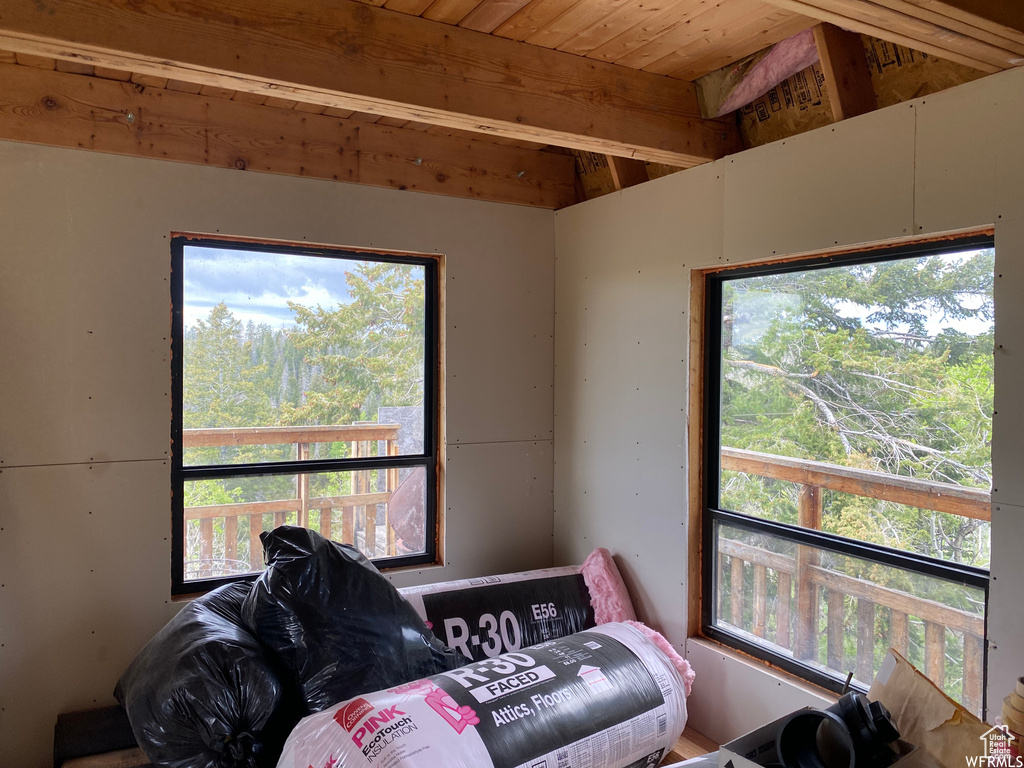 Bedroom featuring vaulted ceiling with beams, multiple windows, and wood ceiling