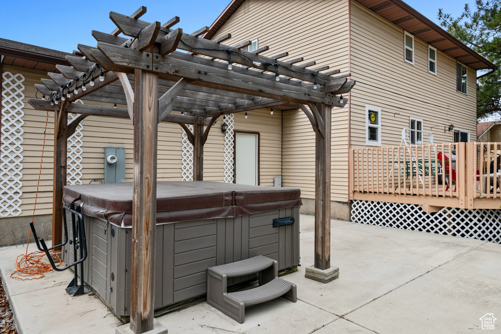 View of patio with a wooden deck, a pergola, and a hot tub