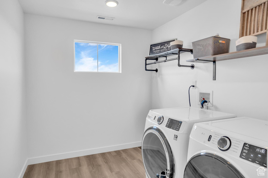 Laundry room with washer hookup, light hardwood / wood-style floors, and independent washer and dryer