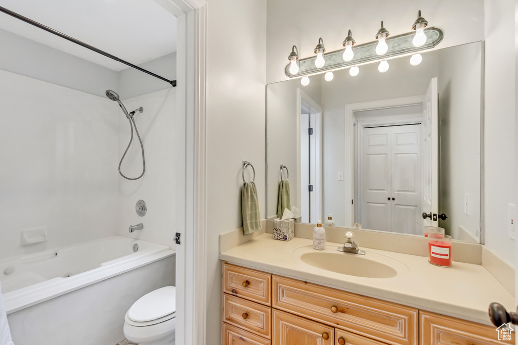 Full bathroom with shower / bathtub combination, oversized vanity, and toilet