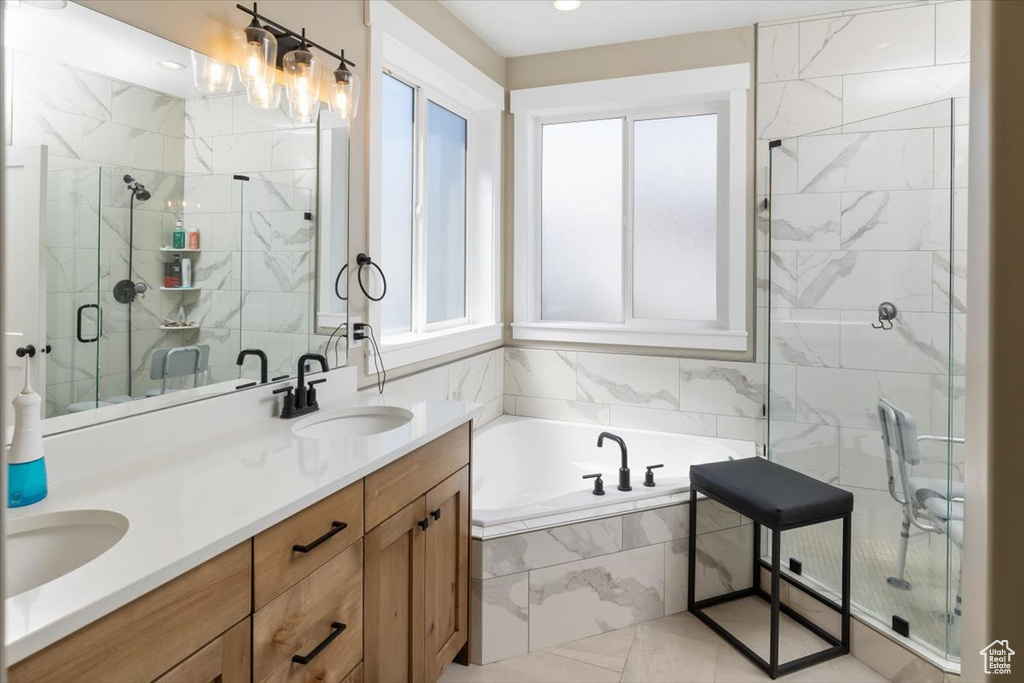 Bathroom with double sink, a healthy amount of sunlight, tile flooring, shower with separate bathtub, and oversized vanity