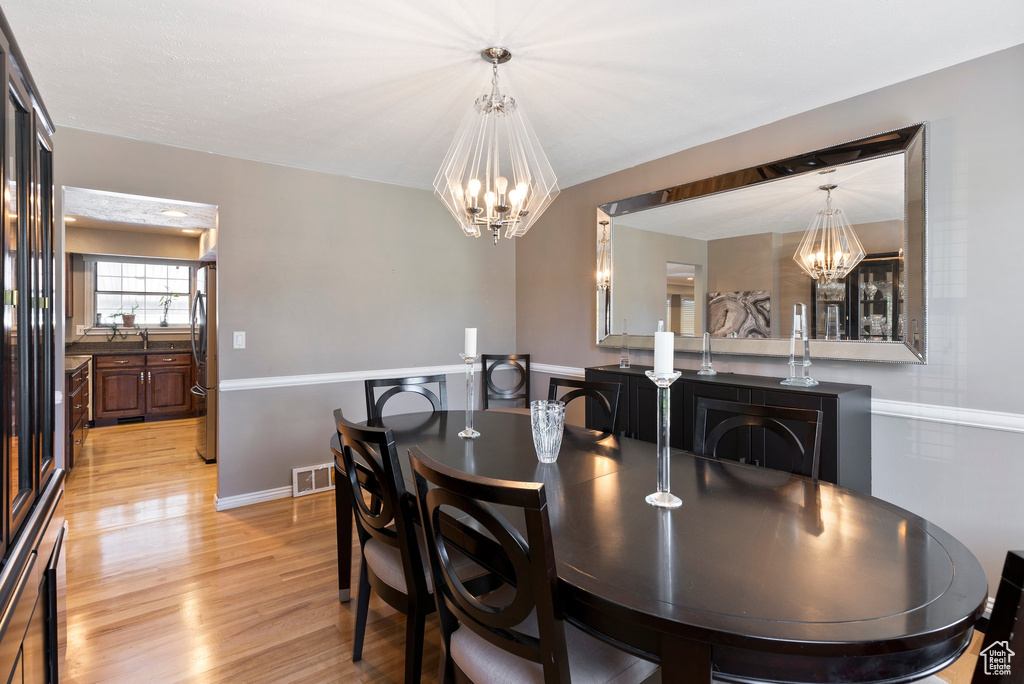 Dining area featuring an inviting chandelier and light hardwood / wood-style flooring