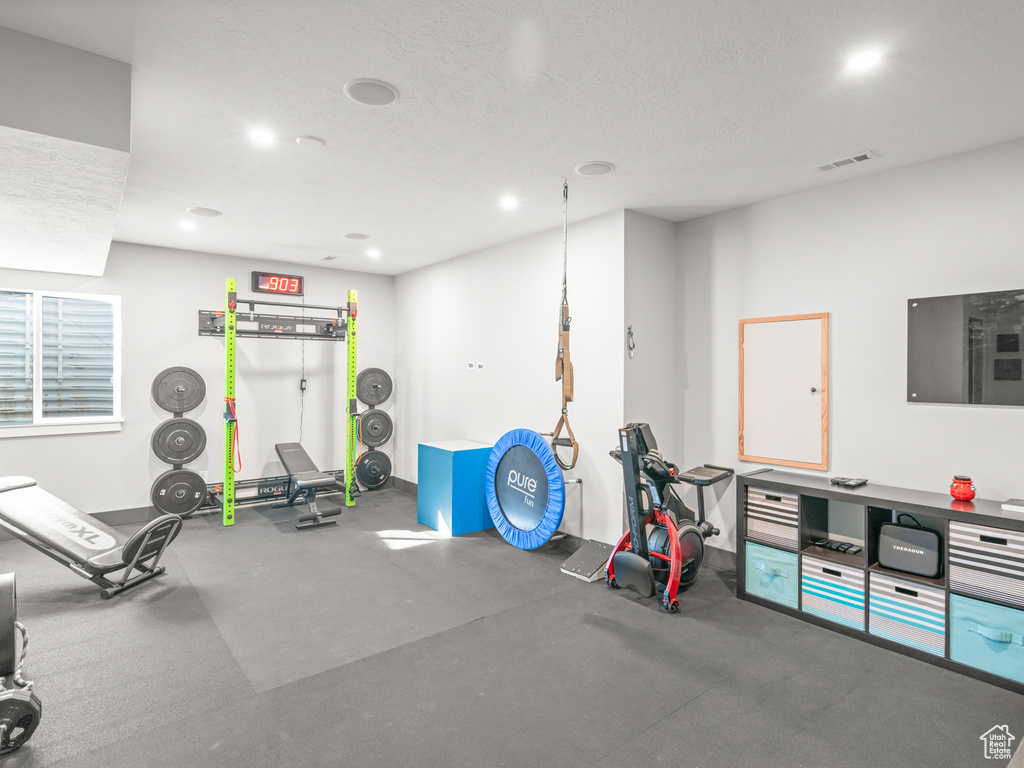 Exercise area with concrete floors and a textured ceiling