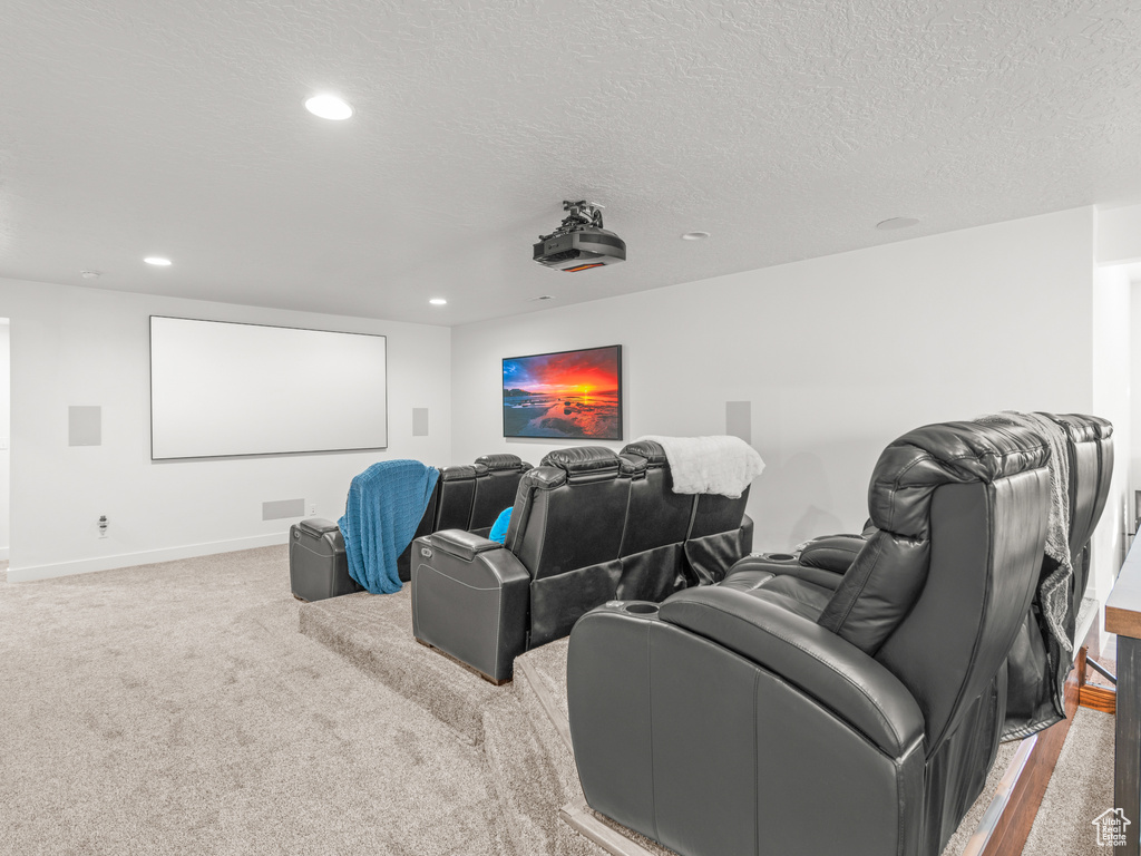 Cinema room featuring carpet flooring and a textured ceiling