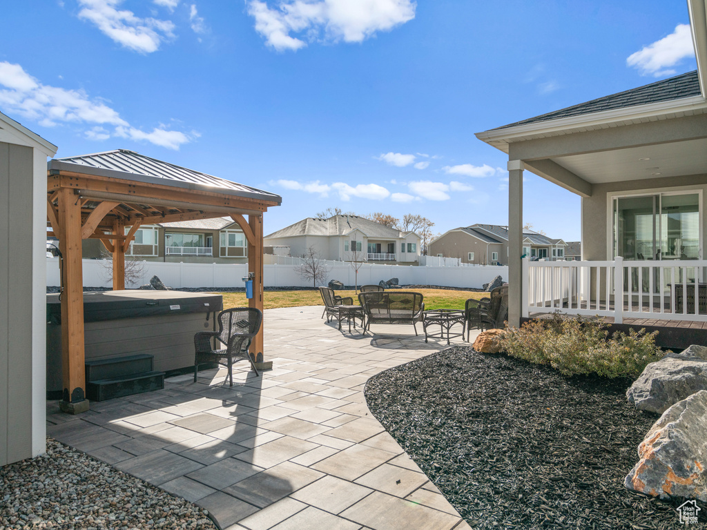 View of patio / terrace featuring a hot tub and a gazebo