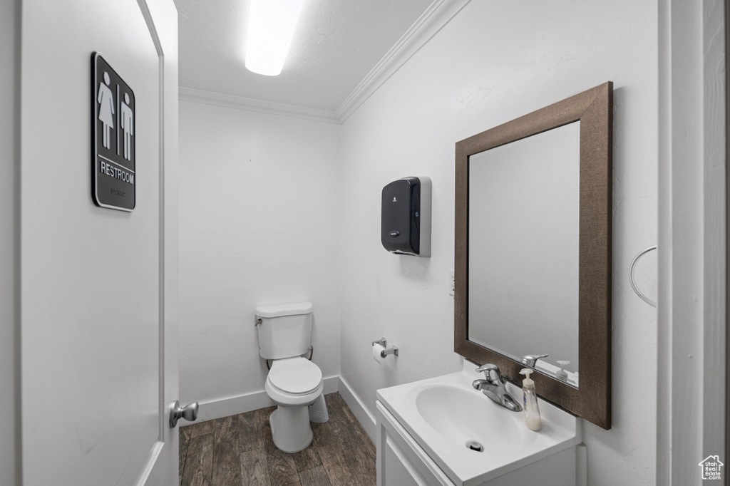 Bathroom featuring vanity, hardwood / wood-style floors, toilet, and ornamental molding