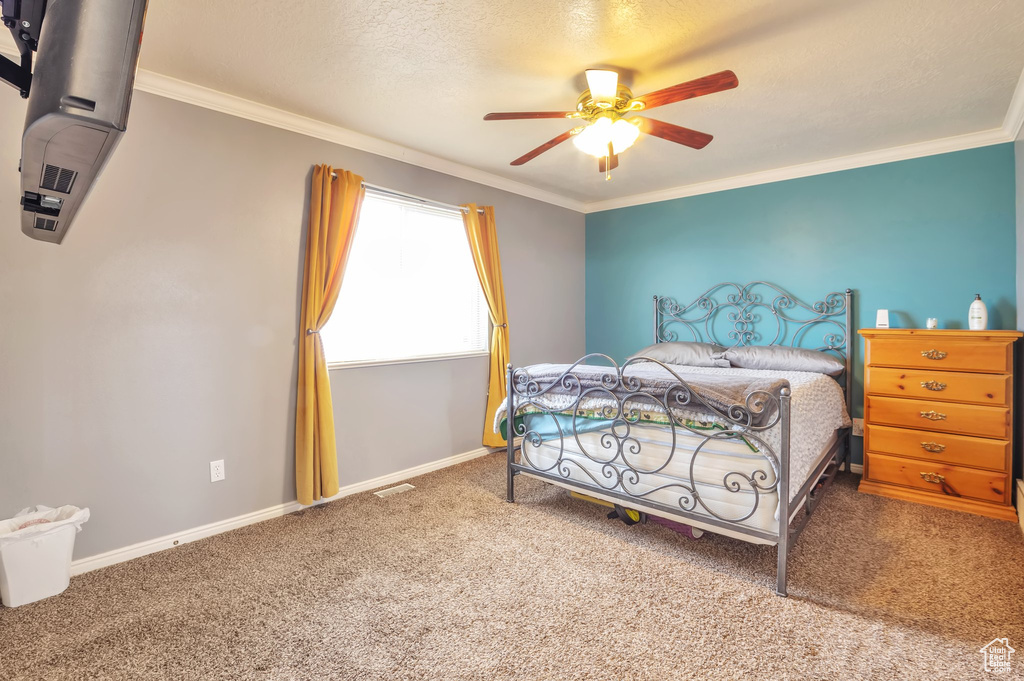 Bedroom with carpet, ornamental molding, and ceiling fan
