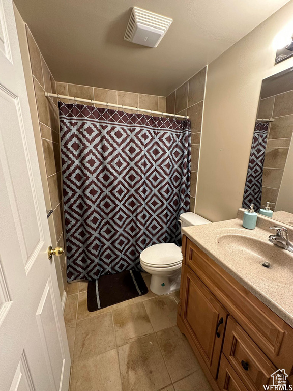 Bathroom featuring toilet, tile floors, and vanity