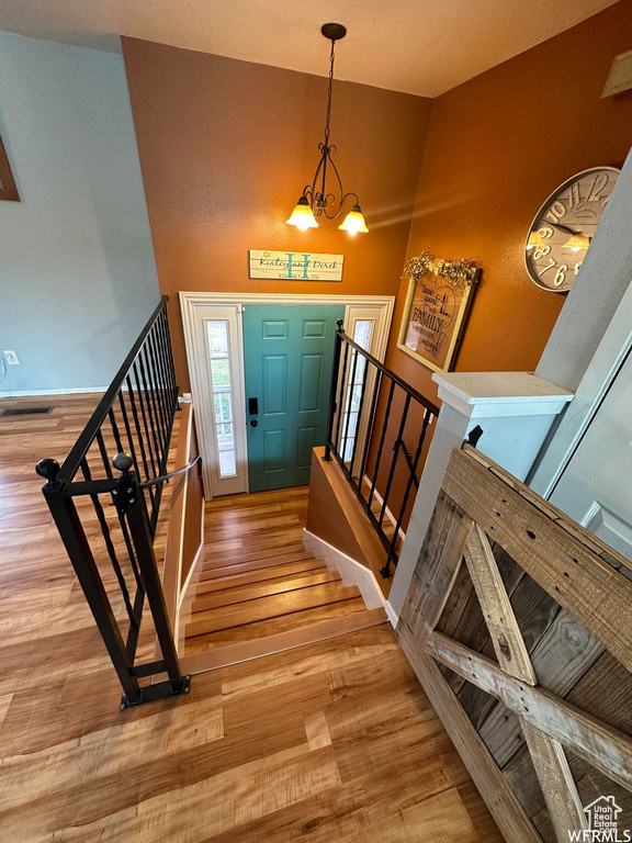 Entryway with light hardwood / wood-style floors, a notable chandelier, and high vaulted ceiling