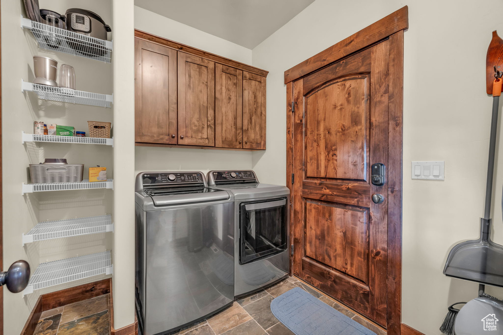 Laundry room featuring separate washer and dryer, tile floors, and cabinets