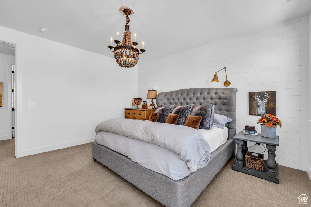 Bedroom featuring an inviting chandelier and light colored carpet