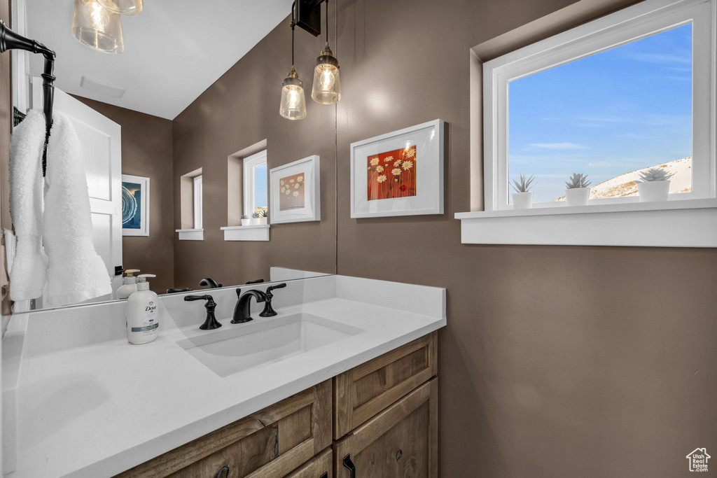 Bathroom featuring vanity with extensive cabinet space and vaulted ceiling