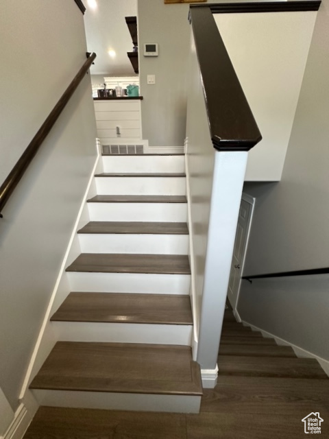 Staircase with dark hardwood / wood-style floors