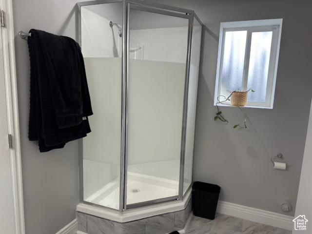 Bathroom featuring a healthy amount of sunlight and a shower with shower door