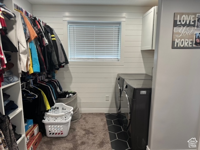 Spacious closet featuring dark carpet and washer and clothes dryer