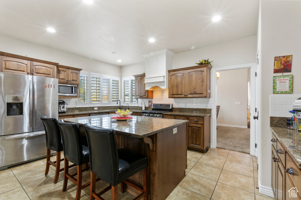 Kitchen featuring backsplash, stainless steel appliances, and a center island
