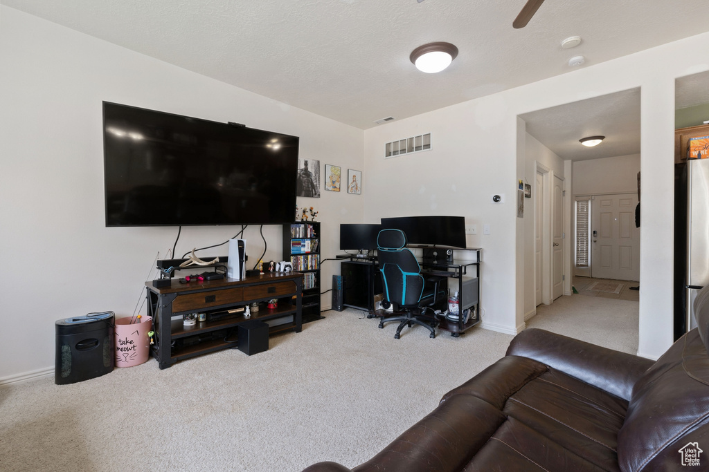 Home office featuring light carpet and ceiling fan