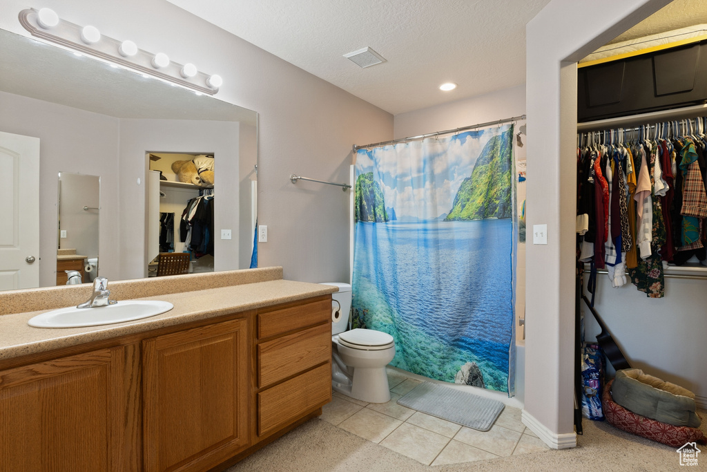 Full bathroom featuring vanity, tile floors, shower / tub combo with curtain, and toilet